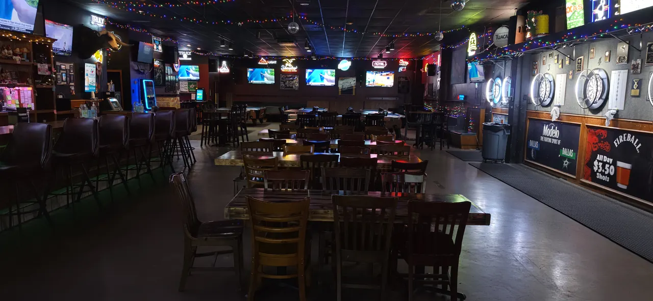 Tables, bar seating and dartboards inside Tumbleweeds Sports Bar